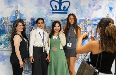 LLM Orientation 2025 students in front of step and repeat