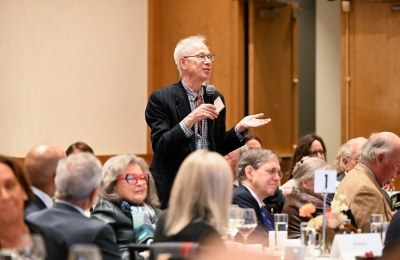 Man at luncheon stands to ask a question