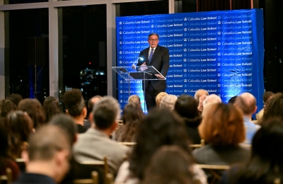 Rolando Acosta standing in front of a podium in front of an audience