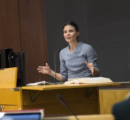  Professor Maeve Glass stands behind a lectern in a classroom at Columbia Law School/