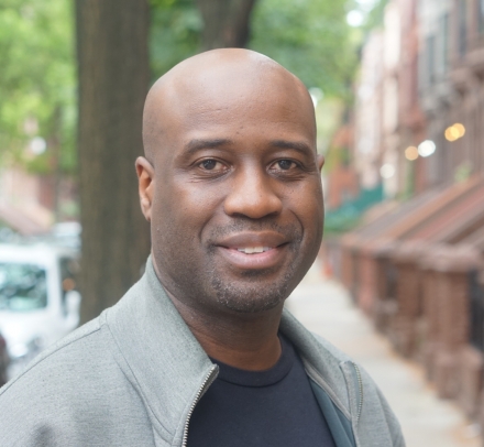 A close-up of multimedia artist Bayeté Ross Smith standing in a New York City street