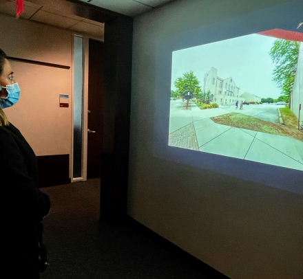 A woman wearing headphones looking at an image on a wall