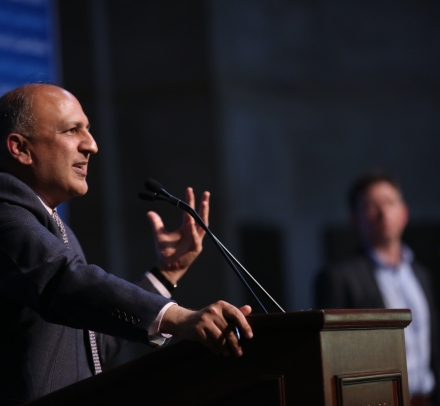 Man speaking and gesturing at podium