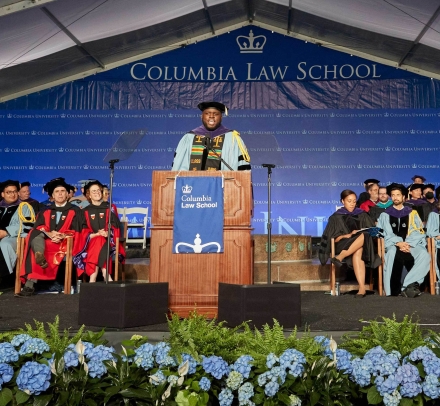 Stage of Columbia Law graduation with hydrangeas and dignitaries