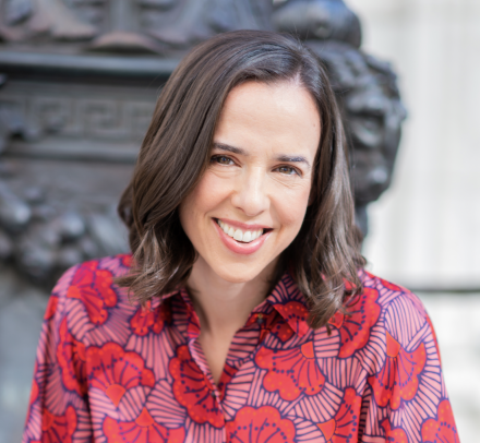 Woman with brown hair in colorful patterned blouse