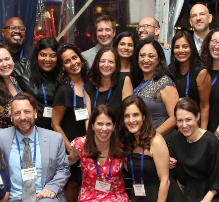 A group of about 20 people posing together