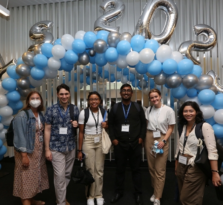 Six members of the class of 2025 pose in front of blue and white balloon arch with additional silver balloons that spell out CLS 2025.