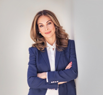 Photo of a woman in a blazer, white shirt, and jeans