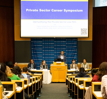 Lecture hall with audience and five person panel in front of room