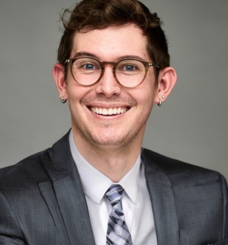 Tyler Henry wearing a suit and smiling
