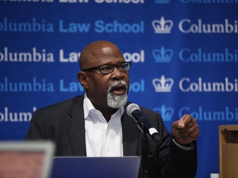 Columbia Law Professor Kendall Thomas in glasses and white shirt in front of mircrophone
