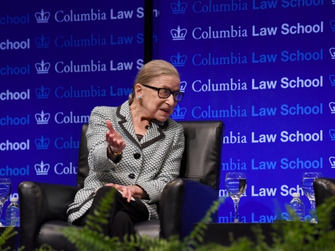 Ruth Bader Ginsburg sitting in front of Columbia Law School step and repeat