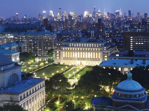 Campus at night with city in the background
