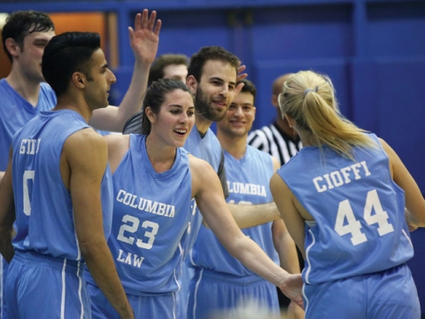 Students giving each other a high five during the Deans Cup basketball game