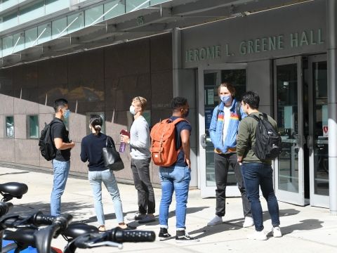 Students wear masks and practice social distancing outside Jerome Greene Hall