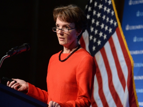 Sarah Cleveland standing at a podium in front of an American flag