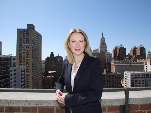 Lucy Lang is blazer on rooftop with NYC skyline