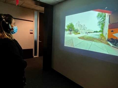 A woman wearing headphones looking at an image on a wall