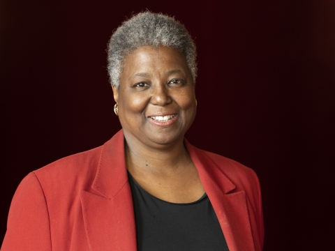 Woman with short gray curls wearing red jacket