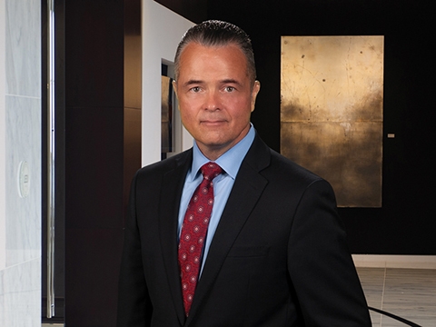 Man in blue shirt, red tie and dark suit jacket