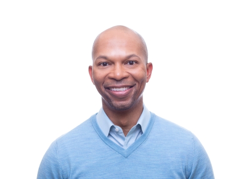 Man in blue V-neck sweater and open collar shirt