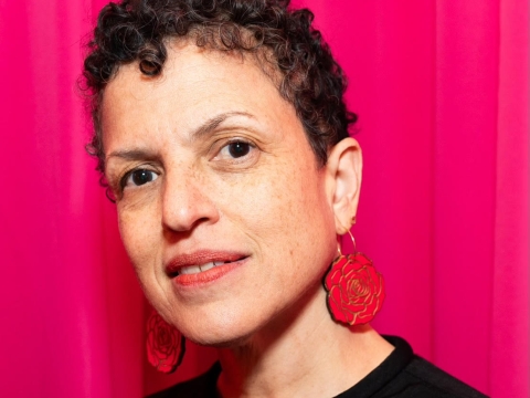 Woman with short dark hair against red background 