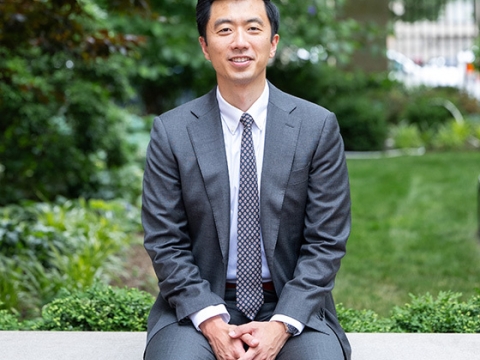Professor Dennis Tan in suit and tie sitting outside