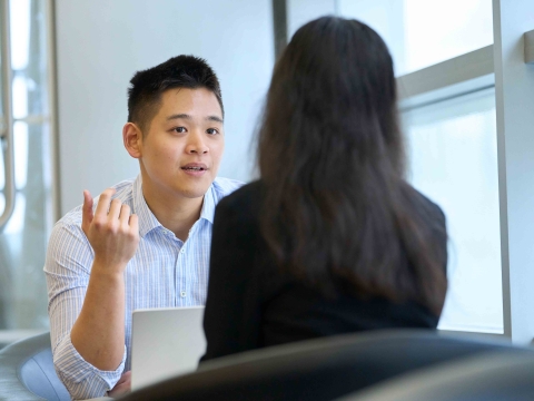 Two students talk together in the Jerome Greene mezzanine.