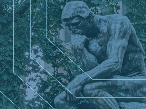 The "Thinker" sculpture in front of a ivy covered wall