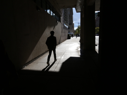 Silhouette of a person walking under the overpass on Amsterdam Avenue towards Jerome Greene Hall.