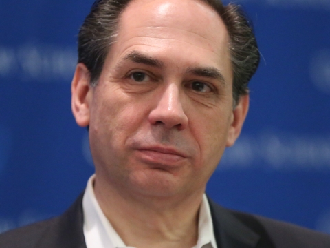Dark-haired man in black suit jacket and white shirt