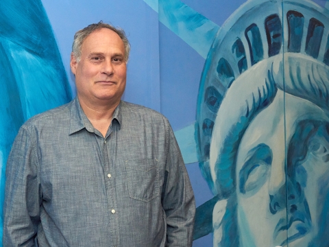 Lee Gelernt ’88 poses by a mural of the Statue of Liberty.