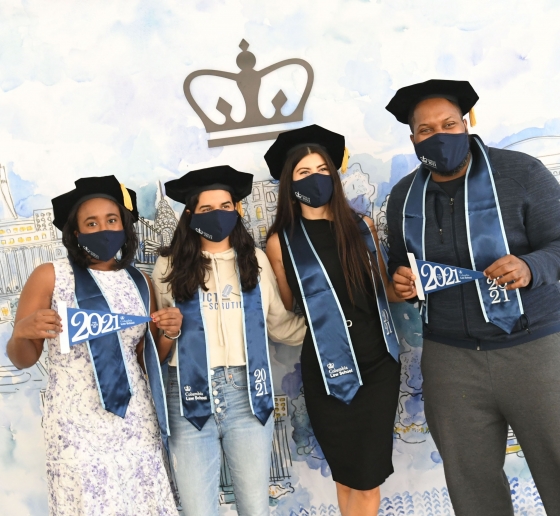 Members of the Class of 2021 pose in front of an illustration of campus