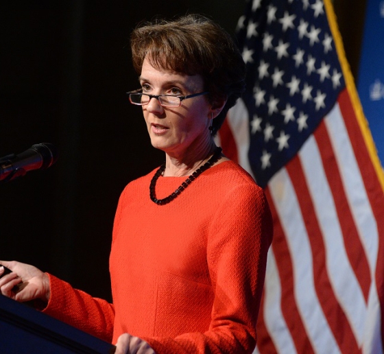 Sarah Cleveland standing at a podium in front of an American flag