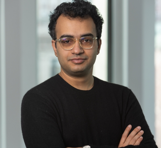 Man in glasses and black sweater with his arms crossed