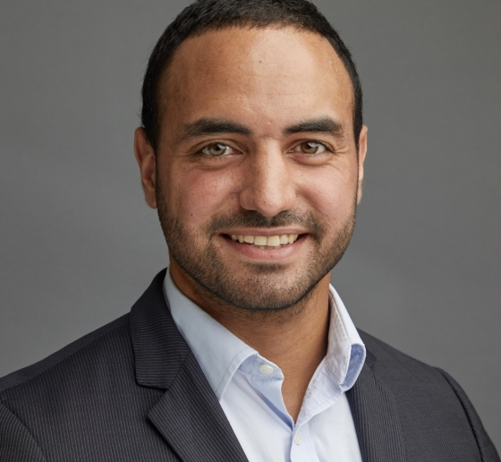 Bearded man with cropped hair in grey jacket