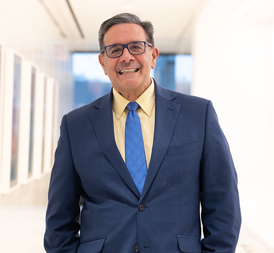 Man with glasses in blue suit and blue tie