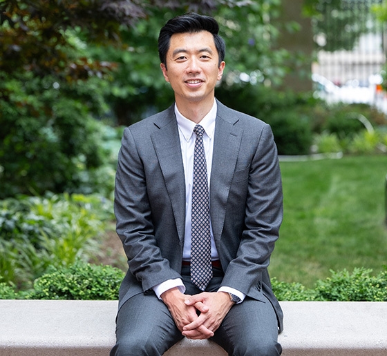 Professor Dennis Tan in suit and tie sitting outside