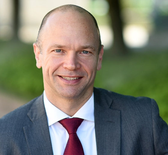 A close-up portrait of a smiling Professor Justin McCrary