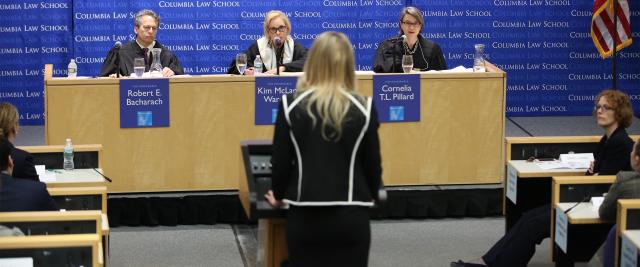 A student stands in front of three judges in Moot Court.