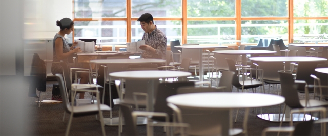 Two students study by a sunny window in the Lenfest Cafe.