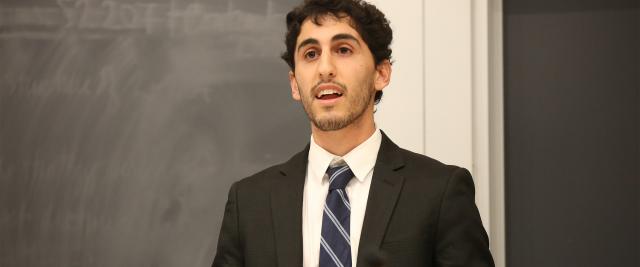 A student in a striped tie speaks in the Moot Court semifinals.