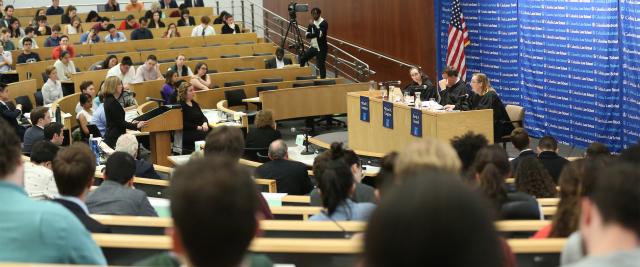 A student stands in front of three judges in Moot Court.