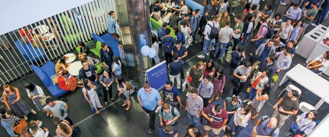 Students stand in a group in the lobby of Jerome Greene Hall.