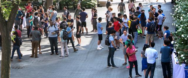 Students socialize in the Wien courtyard and eat ice cream.