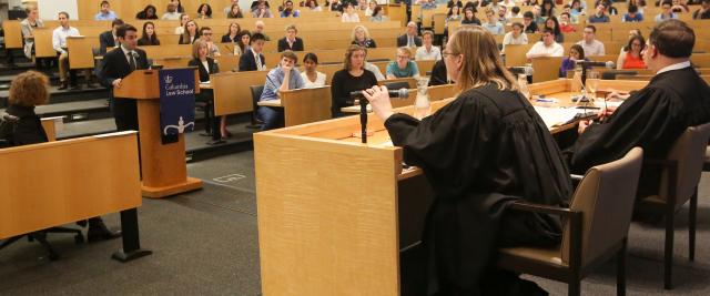 A student stands in front of three judges in Moot Court.