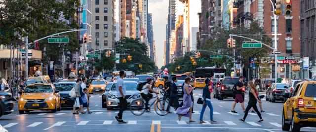 People walking across a busy street in Manhattan