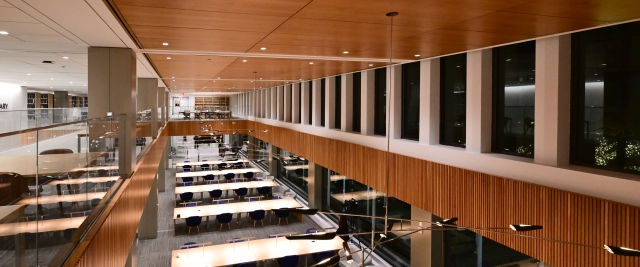Photo looking down a large room with long tables and tall windows