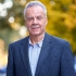 Professor Conrad Johnson stands in front of autumn trees on the Columbia campus.