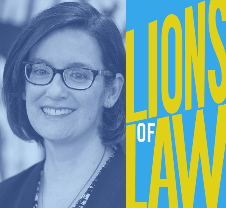Woman with dark hair and glasses with graphic reading Lions of Law